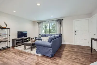 a living room with a blue couch and a television at Charming Family Friendly 4bd 2ba Arvada Home in Arvada