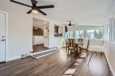 a living room with a ceiling fan and a table and chairs at Charming Family Friendly 4bd 2ba Arvada Home in Arvada