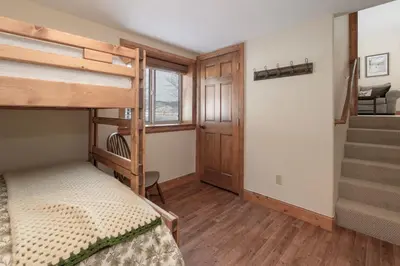 a bedroom with two bunk beds and a staircase at Luxe MTN Escape 15 min to Winter Park Base in Tabernash