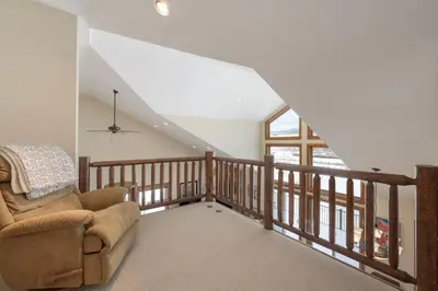 a living room with a chair and a staircase at Luxe MTN Escape 15 min to Winter Park Base in Tabernash