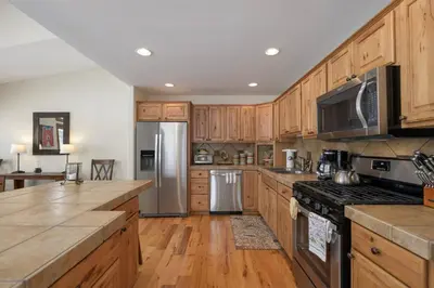 a kitchen with wooden cabinets and stainless steel appliances at Luxe MTN Escape 15 min to Winter Park Base in Tabernash