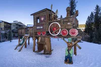 a person standing in front of a wooden play structure in the snow at Luxe Home Minutes To Skiing Hot Tub in Winter Park