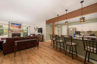 a kitchen and living room with a couch and a fireplace at Luxe Home Minutes To Skiing Hot Tub in Winter Park