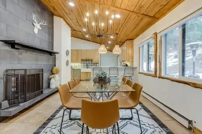 a dining room with a glass table and chairs and a fireplace at Mountain Mansion with Hot Tub and Sauna in Morrison