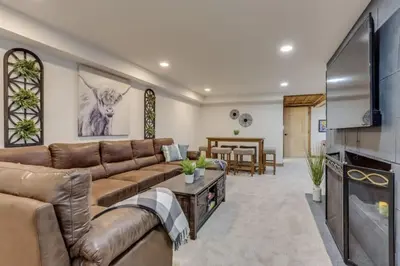 a living room with a couch and a flat screen tv at Mountain Mansion with Hot Tub and Sauna in Morrison