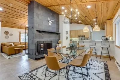 a dining room with a glass table and chairs and a fireplace at Mountain Mansion with Hot Tub and Sauna in Morrison
