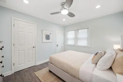 a white bedroom with a bed and a ceiling fan at DU Cherry Creek Bungalow Sleeps 4 in Denver