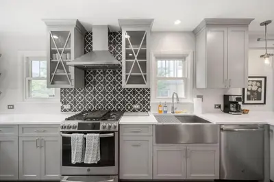 a white kitchen with a stove and a sink at DU Cherry Creek Bungalow Sleeps 4 in Denver