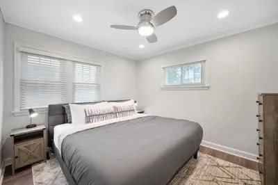 a white bedroom with a bed and a ceiling fan at DU Cherry Creek Bungalow Sleeps 4 in Denver