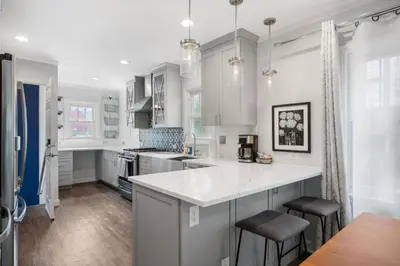 a kitchen with white cabinets and a white counter top at DU Cherry Creek Bungalow Sleeps 4 in Denver