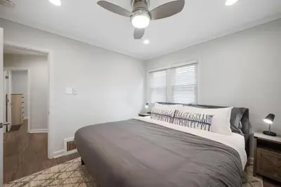 a white bedroom with a bed with a ceiling fan at DU Cherry Creek Bungalow Sleeps 4 in Denver