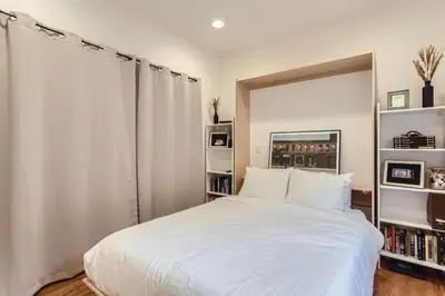 a bedroom with a large white bed and bookshelves at RINO Five Points Downtown in Denver