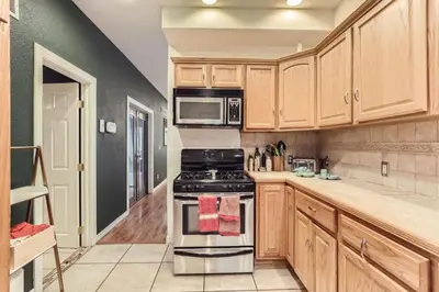 a kitchen with wooden cabinets and a stove top oven at RINO Five Points Downtown in Denver