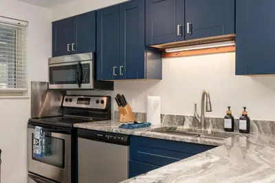 a kitchen with blue cabinets and a stove top oven at Winter Park Chalet I Mtn Biking I Summer festivals in Winter Park
