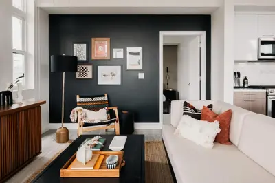 a living room with a white couch and a black wall at 2880 Rhythm of the Night Loft at Espadin in Denver
