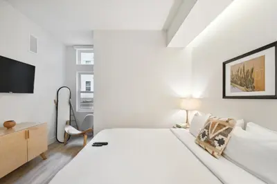 a white bedroom with a bed and a tv at 2880 Natural Influence Sanctuary at Espadin in Denver