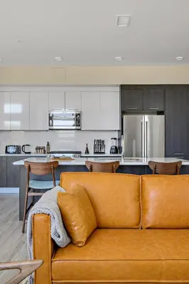 a living room with a brown couch in a kitchen at 2880 Modern Lifestyle Loft at Espadin in Denver