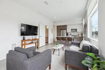 a living room with two couches and a kitchen at 2880 Highline Hideaway at Espadin in Denver