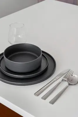 a black plate on a table with a fork and knife at 2880 Sky-High LoHi Oasis at Espadin in Denver