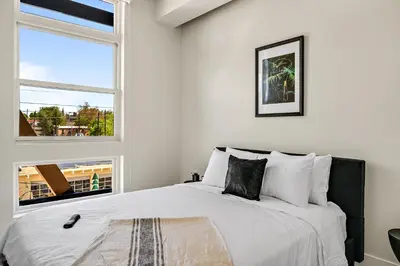 a white bedroom with a large bed with a window at 2880 Canvas & Comfort at Espadin in Denver
