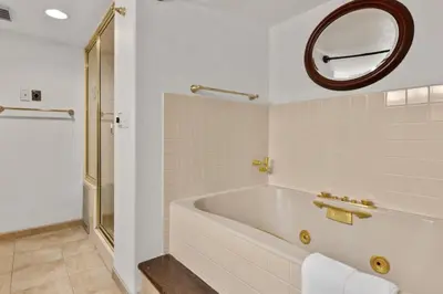 a white bathroom with a tub and a mirror at City Center Oasis Prime Location with Views in Denver