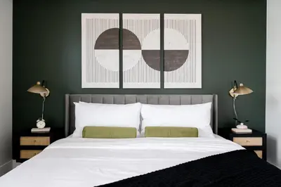 a bedroom with a bed with green walls and two lamps at 2880 Serenity in Style in Denver
