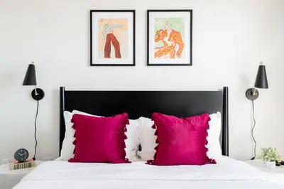 a bedroom with pink pillows and two framed posters at 2880 Serenity in Style in Denver