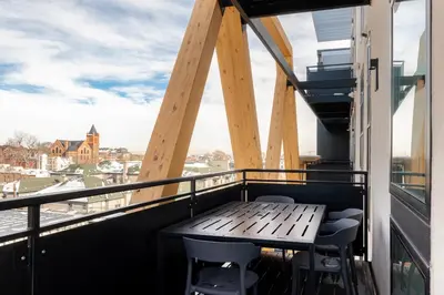 a balcony with a wooden table and chairs at 2880 Serenity in Style in Denver