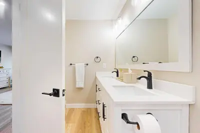 a white bathroom with a sink and a mirror at SunSong Escape in Fraser