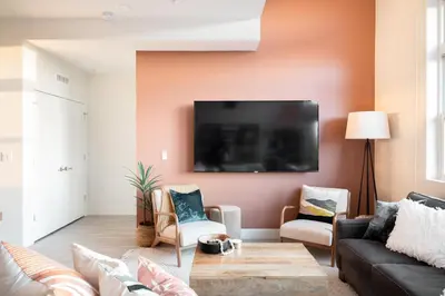 a living room with a couch and a tv on a wall at 2880 Bold & Elevated in Denver