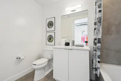 a white bathroom with a toilet and a sink at RiNo Art Lofts in Denver