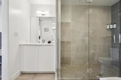 a bathroom with a glass shower stall and a sink at RiNo Art Lofts in Denver