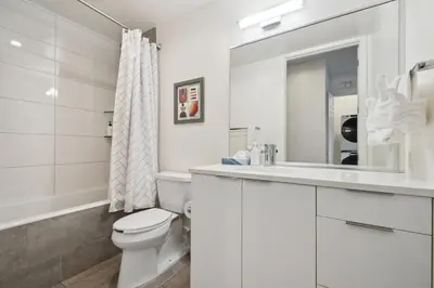 a white bathroom with a toilet and a sink at 3198 Industrial Chic at RiNo Art Lofts in Denver