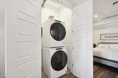 a washer and dryer in a white room with a bed at 3198 Industrial Chic at RiNo Art Lofts in Denver