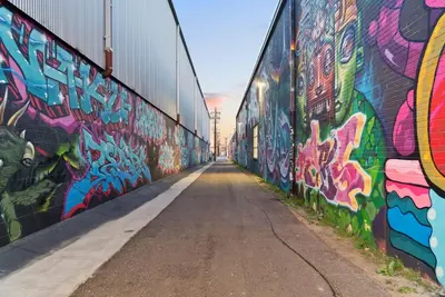 a wall covered in graffiti next to a street at 3198 Industrial Chic at RiNo Art Lofts in Denver