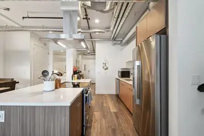 an open kitchen with a stainless steel refrigerator at 3198 Industrial Chic at RiNo Art Lofts in Denver