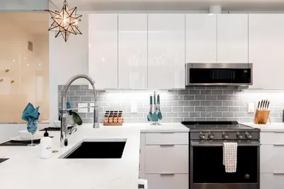 a white kitchen with a sink and a stove at 3198 Bohemian Hideaway at RiNo Art Lofts in Denver