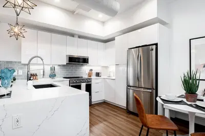 a kitchen with white cabinets and a stainless steel refrigerator at 3198 Bohemian Hideaway at RiNo Art Lofts in Denver