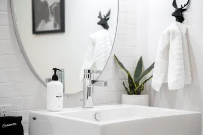 a white bathroom with a sink and a mirror at 3198 Bohemian Hideaway at RiNo Art Lofts in Denver