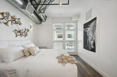 a white bedroom with a large bed and a window at 3198 Urban Cowboy Escape at RiNo Art Lofts in Denver