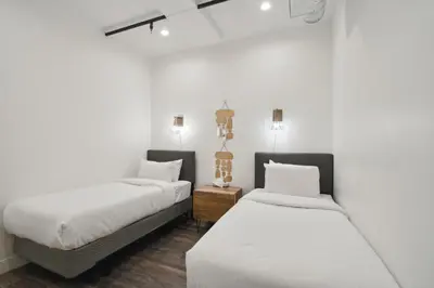 two beds in a room with white walls at 3198 Urban Cowboy Escape at RiNo Art Lofts in Denver