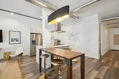 a kitchen with a wooden table and stools at 3198 Urban Cowboy Escape at RiNo Art Lofts in Denver