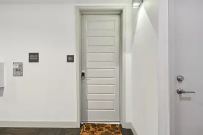 a white door in a white hallway with a rug at 3198 Graffiti & Skyline at RiNo Art Lofts in Denver