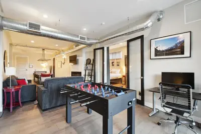 a living room with a ping pong table and a couch at 3198 Graffiti & Skyline at RiNo Art Lofts in Denver