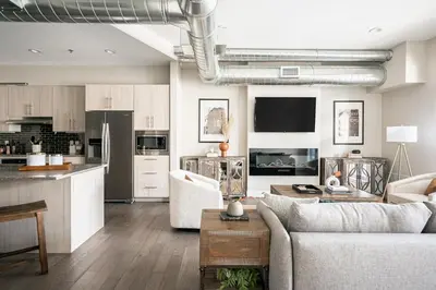 a living room with a couch and a kitchen at 3198 Bright & Breezy at RiNo Art Lofts in Denver
