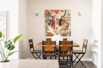 a dining room table with chairs and a painting on the wall at 3198 Bright & Breezy at RiNo Art Lofts in Denver