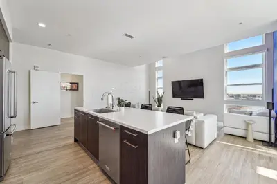 a kitchen with a sink and a living room at 2880 The Penthouse at Espadin in Denver