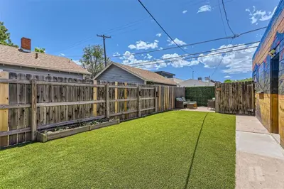 a backyard with a wooden fence and grass at At S. Broadway An Artsy Bungalow Close to DU And Cherry Hills in Englewood
