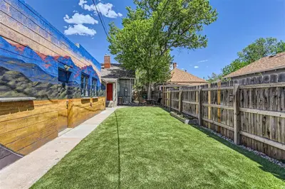 a backyard with a fence and grass at At S. Broadway An Artsy Bungalow Close to DU And Cherry Hills in Englewood