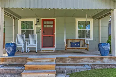 a porch with two chairs and a red door at At S. Broadway An Artsy Bungalow Close to DU And Cherry Hills in Englewood